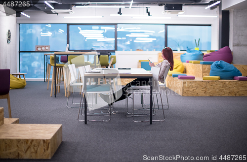 Image of redhead businesswoman using mobile phone at office