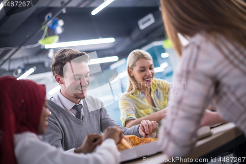 Image of multiethnic business team eating pizza