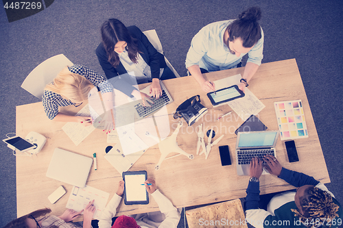 Image of top view of multiethnic business team learning about drone techn