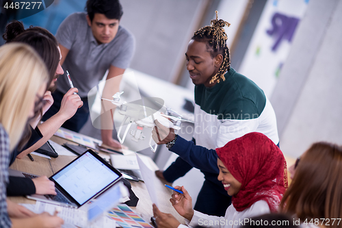 Image of multiethnic business team learning about drone technology