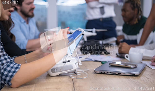 Image of multiethnic business team learning about drone technology