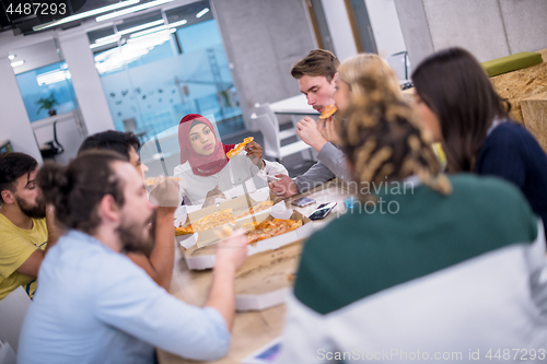 Image of multiethnic business team eating pizza