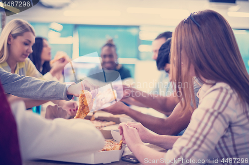 Image of multiethnic business team eating pizza