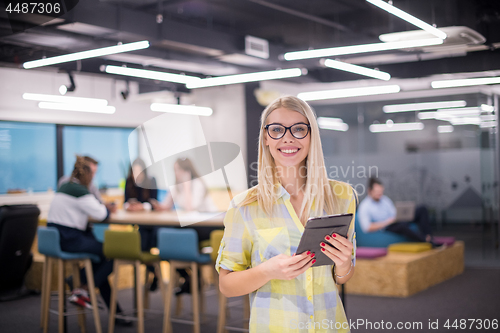 Image of blonde businesswoman working online using digital tablet