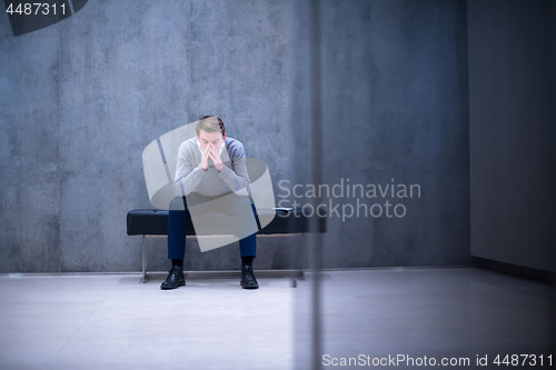 Image of businessman using smart phone while sitting on the bench