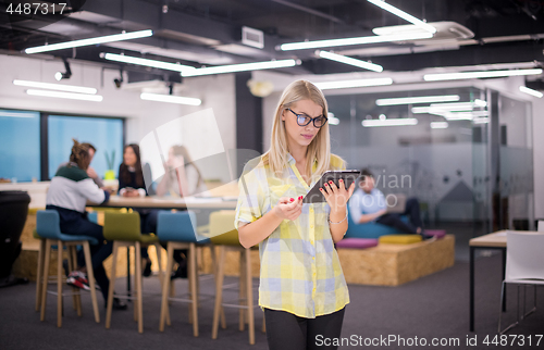 Image of blonde businesswoman working online using digital tablet