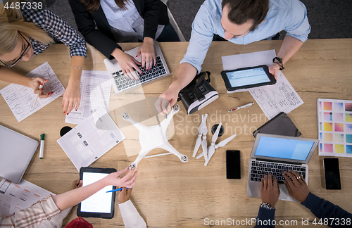 Image of top view of multiethnic business team learning about drone techn