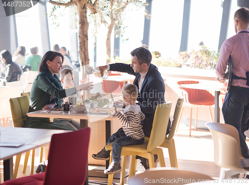 Image of Young parents enjoying lunch time with their children