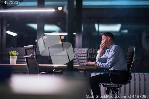 Image of man working on laptop in dark office