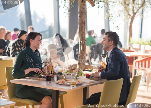 Image of Young parents enjoying lunch time with their children