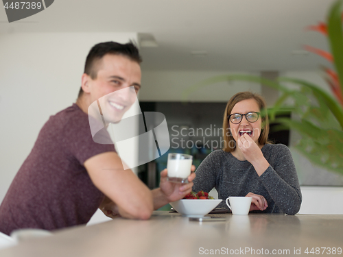 Image of couple enjoying morning coffee and strawberries