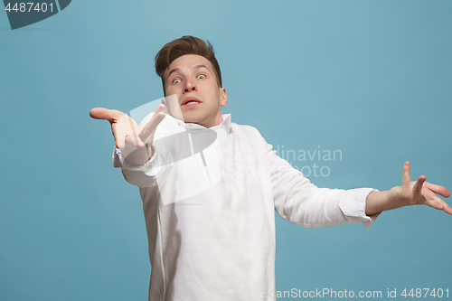 Image of Beautiful male half-length portrait isolated on studio backgroud. The young emotional surprised man