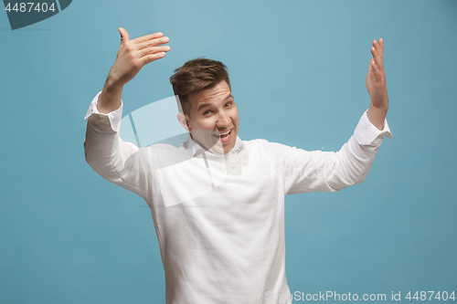 Image of Beautiful male half-length portrait isolated on studio backgroud. The young emotional surprised man