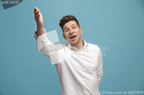 Image of Beautiful male half-length portrait isolated on studio backgroud. The young emotional surprised man