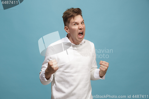 Image of The young emotional angry man screaming on studio background