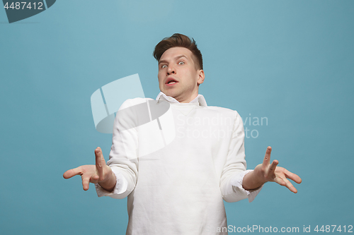 Image of Beautiful male half-length portrait isolated on studio backgroud. The young emotional surprised man