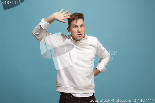 Image of Beautiful male half-length portrait isolated on studio backgroud. The young emotional surprised man