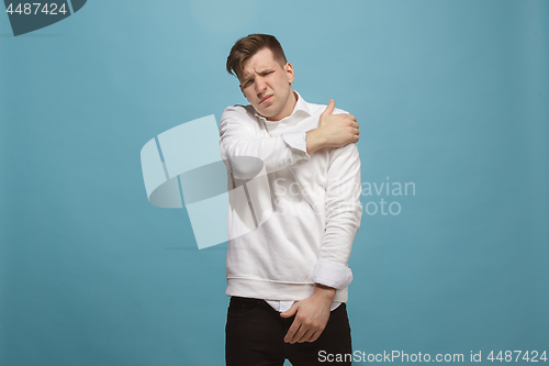 Image of Young man overwhelmed with a pain in the shoulder