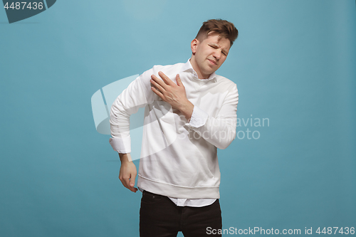 Image of Young man overwhelmed with a pain in the shoulder