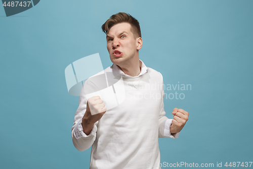 Image of The young emotional angry man screaming on studio background