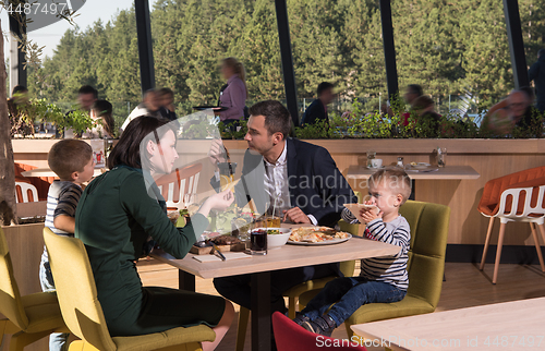 Image of Young parents enjoying lunch time with their children