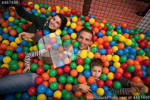 Image of young parents with kids in a children\'s playroom