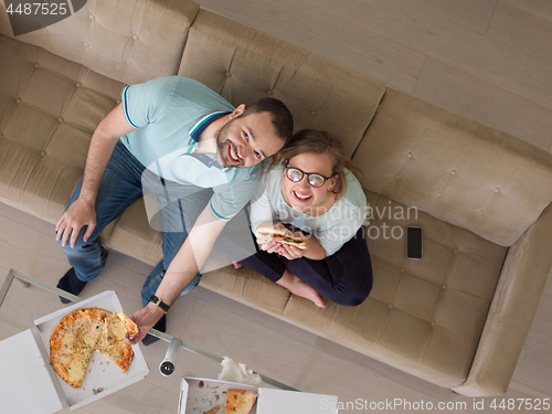 Image of couple eating pizza in their luxury home villa