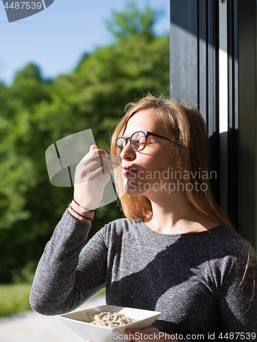 Image of woman eating breakfast in front of her luxury home villa