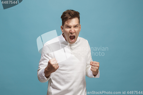 Image of The young emotional angry man screaming on studio background