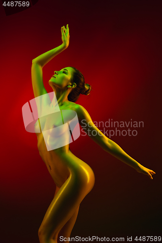 Image of fashion art photo of elegant nude model in the light colored spotlights