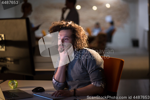 Image of man working on computer in dark office