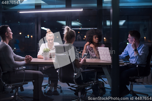 Image of Multiethnic startup business team in night office