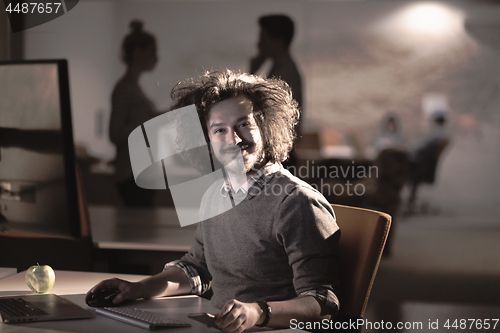 Image of man working on computer in dark office