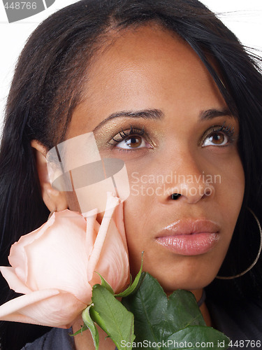 Image of Young black woman with pink rose along cheek