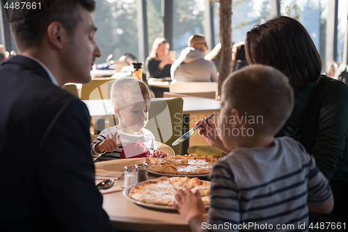 Image of Young parents enjoying lunch time with their children