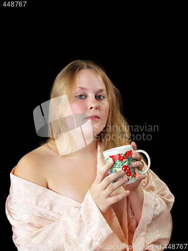 Image of Young plump woman in robe with coffee cup