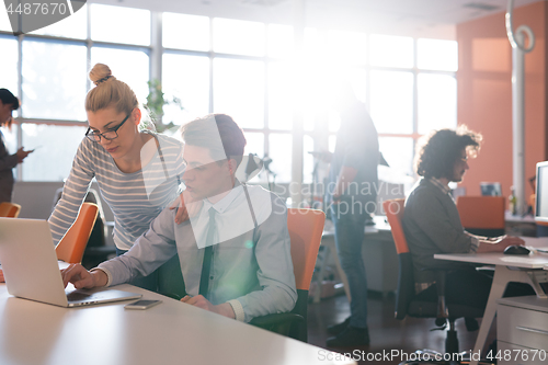 Image of Two Business People Working With laptop in office