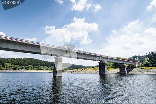 Image of Bridge over a lake with a forest in the background