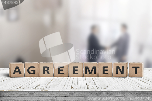 Image of Agreement sing on a word with business men 