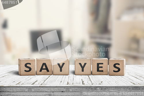 Image of Say yes sign on a wooden desk in a bright room