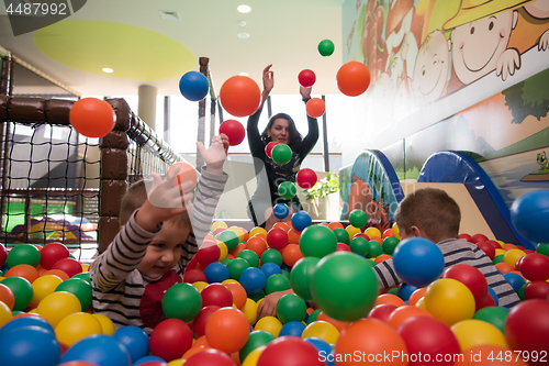 Image of Young mom with her kids in a children\'s playroom