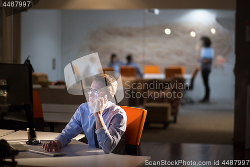 Image of man using mobile phone in dark office