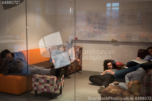 Image of software developers sleeping on sofa in creative startup office