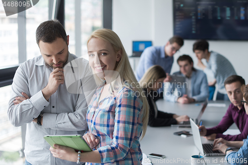 Image of Two Business People Working With Tablet in office