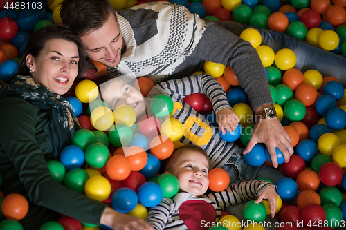 Image of young parents with kids in a children\'s playroom