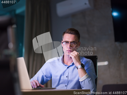 Image of man working on laptop in dark office