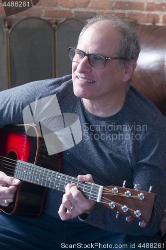 Image of middle age senior man playing guitar