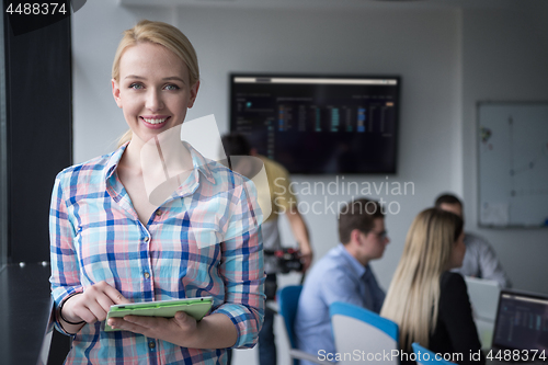 Image of Pretty Businesswoman Using Tablet In Office Building by window