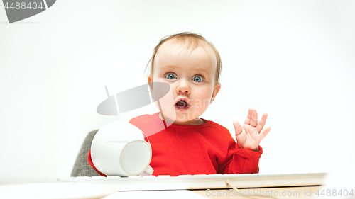 Image of Happy child baby girl toddler sitting with keyboard of computer isolated on a white background