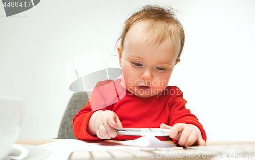 Image of Happy child baby girl toddler sitting with keyboard of computer isolated on a white background